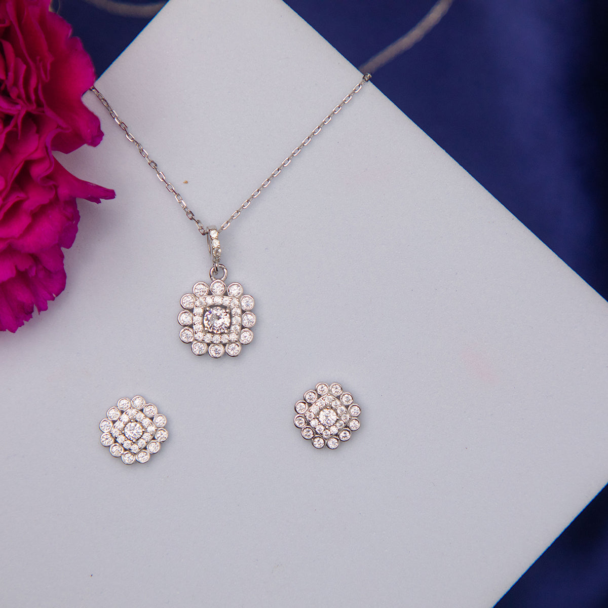 A set of sterling silver jewelry including a pendant and a pair of earrings, featuring white stone embellishments.