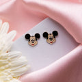 Kids Mickey mouse earring fro young girls at a white background with pink fabric along with floral aesthetics available at Asesha Jewels, the online silver jewelry store. Contains earrings, pendant set, bracelets for kids