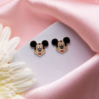 Kids Mickey mouse earring fro young girls at a white background with pink fabric along with floral aesthetics available at Asesha Jewels, the online silver jewelry store. Contains earrings, pendant set, bracelets for kids