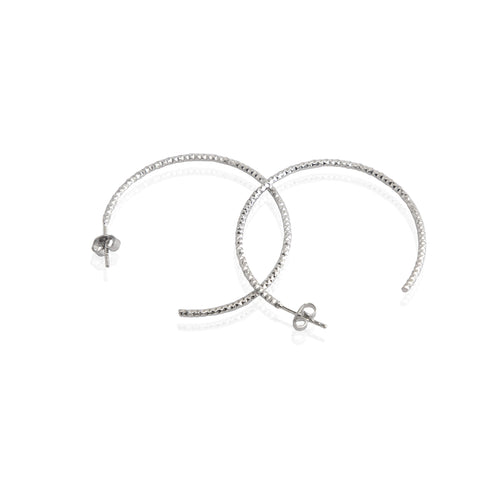 A pair of sterling silver textured hoop earrings with a rhodium-based anti-tarnish coating.
