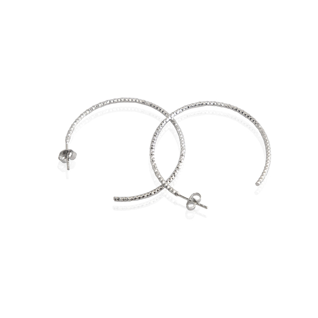 A pair of sterling silver textured hoop earrings with a rhodium-based anti-tarnish coating.