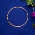A twisted silver bracelet displayed on a blue background with a floral accent.