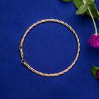 A twisted silver bracelet displayed on a blue background with a floral accent.