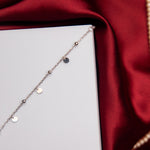 A Fine Silver Charm Bracelet with rhodium-based anti-tarnish coating, displayed on a red satin surface.