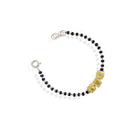 A kids' bracelet made of sterling silver with a golden color, featuring alphabet blocks as the design.